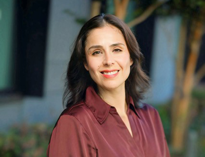 Woman with dark, shoulder-length and a silk, maroon blouse